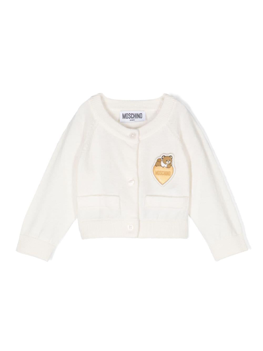 Cardigan per neonata Moschino Kids bianco con applicazione logo sul petto – Accessorio premium elegante